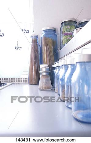 Stock Image - Row of jars of spices in kitchen . Fotosearch