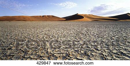 Stock Photo - Salt pan with sand dunes in background, Sossusvlei, Namib-Naukluft National Park, Namib Desert, Swakopmund, Namibia . Fotosearch