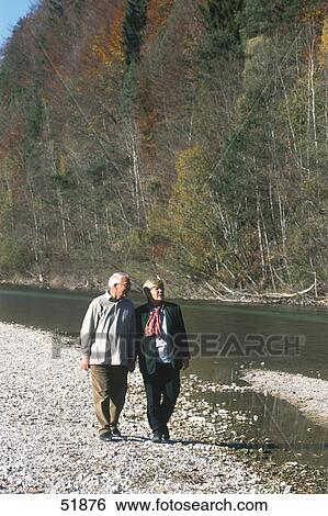 Senior couple walking near river View Large Photo Image Stock Photograph - Senior couple walking near river . Fotosearch