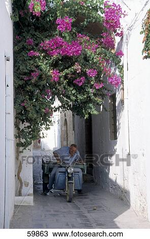Stock Image - Senior man riding tricycle in street . Fotosearch