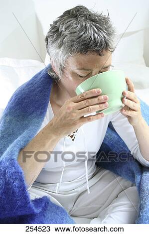 Stock Image - Senior woman inhaling steam for a cold . Fotosearch