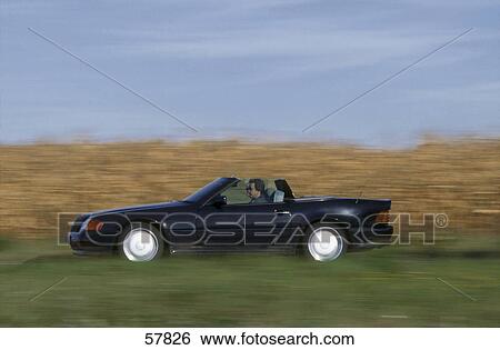 Side profile of man driving convertible car on road View Large Photo Image Stock Photograph - Side profile of man driving convertible car on road . Fotosearch