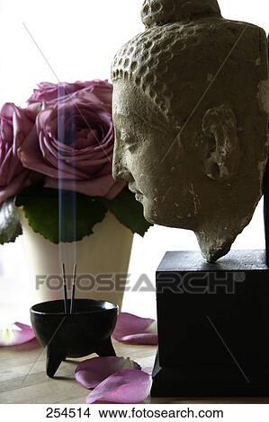 Picture - Side profile of statue of Buddha and incense in bowl . Fotosearch