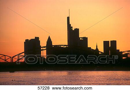 Stock Photo - Silhouette of bridge across river with city skyline in background, Commerzbank, Main River, Frankfurt, Hessen, Germany . Fotosearch