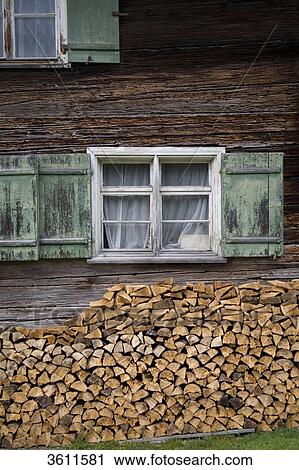 Stock Image - Stack of wood in front of wooden house, Bavaria, Germany, Europe . Fotosearch
