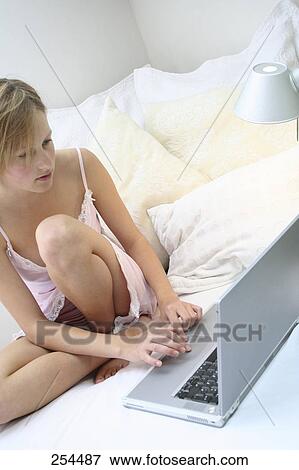 Stock Photo - Teenage girl using a laptop in bed . Fotosearch