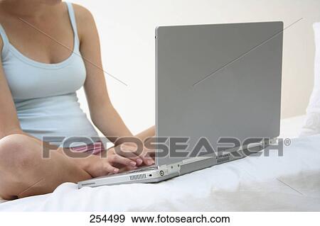 Stock Photo - Teenage girl using a laptop in bed . Fotosearch