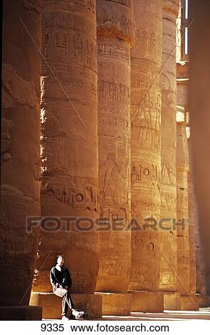 Stock Photography - Tourist sitting near columns of temple, Temple Of Karnak, Egypt . Fotosearch