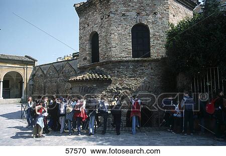 Stock Image - Tourists near a church, Arian Baptistery, Ravenna, Emilia-Romagna, Italy . Fotosearch