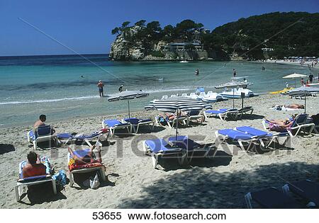 Stock Photography - Tourists relaxing on beach, Cala Galdana, Minorca, Balearic Islands, Spain . Fotosearch