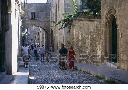 Stock Photography - Tourists walking in lane of town, Palace of the Grand Master of the Knights, Rhodes, Dodecanese Islands, Greece . Fotosearch