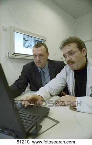 Stock Image - Two doctors using laptop . Fotosearch