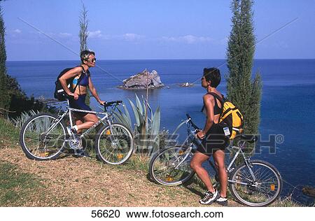 Two female cyclists talking to each other on cape, Cyprus, Greece View Large Photo Image Stock Image - Two female cyclists talking to each other on cape, Cyprus, Greece . Fotosearch