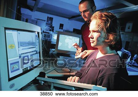 Stock Image - Two young men working on a computer . Fotosearch