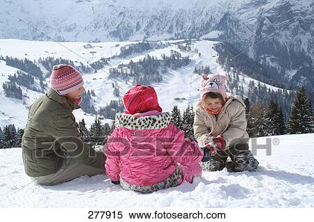 Woman and her children playing in snow View Large Photo Image Stock Photography - Woman and her children playing in snow . Fotosearch