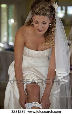 Young bride putting on garter View Large Photo Image Stock Photo - Young bride putting on garter . Fotosearch