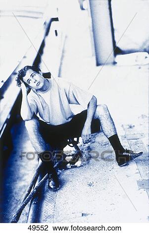 Young man sitting on street and looking sad View Large Photo Image Stock Image - Young man sitting on street and looking sad . Fotosearch