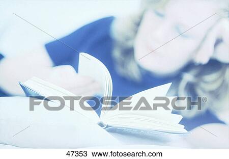 Stock Image - Young woman reading a book . Fotosearch