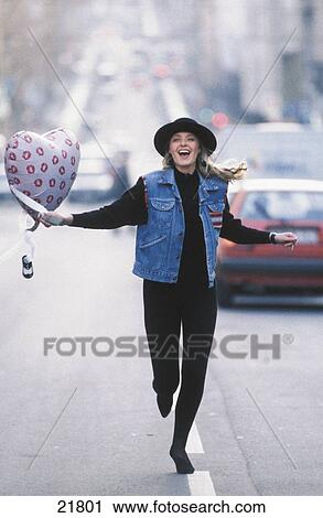 Young woman running on the road with a balloon View Large Photo Image Stock Image - Young woman running on the road with a balloon . Fotosearch