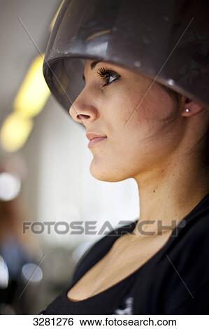 Stock Photograph - Young woman under drying hood in hair salon . Fotosearch