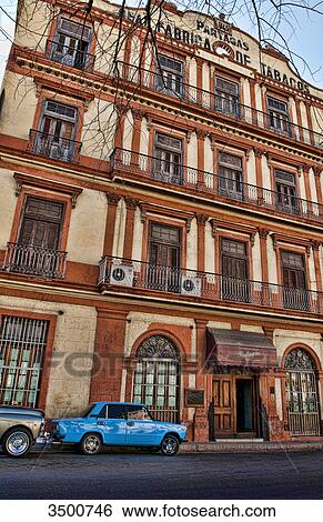 Stock Photograph - Car in front of Partagas Cigar Factory in Havana, Cuba . Fotosearch