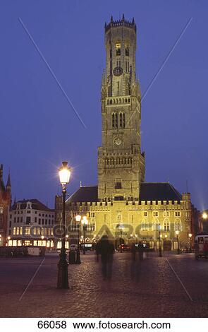 Clock tower lit up at night against blue sky, Bruegge, Belgium  View Large Photo Image Stock Photo - Clock tower lit up at night against blue sky, Bruegge, Belgium . Fotosearch