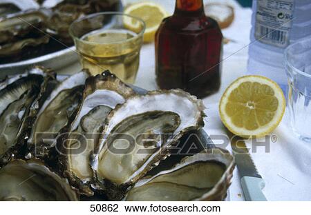 Close-up of a plate of oysters with lemons and white wine View Large Photo Image Stock Image - Close-up of a plate of oysters with lemons and white wine . Fotosearch