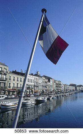 Stock Image - Close-up of French flag over canal, Port of Sete, France . Fotosearch