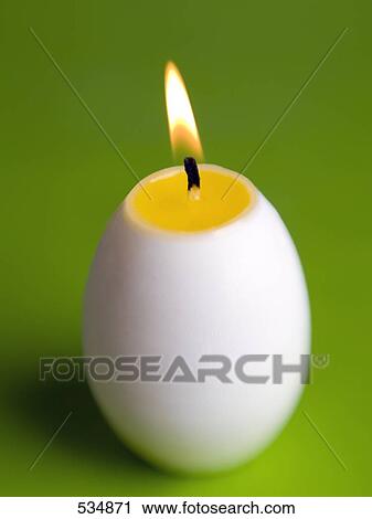 Stock Image - Close-up of lit egg shaped candle . Fotosearch
