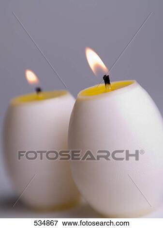 Stock Photo - Close-up of lit egg shaped candles . Fotosearch