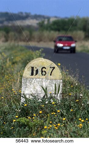 Close-up of milestone with car moving on road in background, Narbonne, Languedoc-Rousillon, France View Large Photo Image Stock Image - Close-up of milestone with car moving on road in background, Narbonne, Languedoc-Rousillon, France . Fotosearch