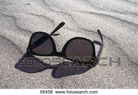 Stock Photo - Close-up of sunglasses in sand . Fotosearch