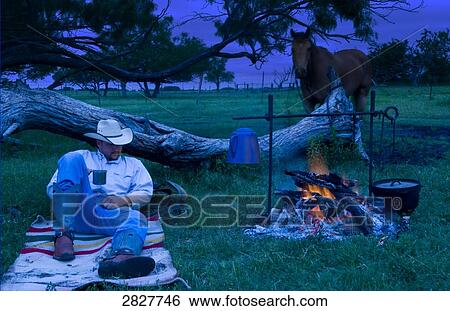 Stock Photograph - Cowboy resting beside a campfire . Fotosearch