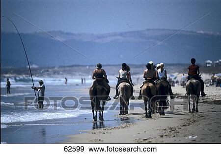 Stock Photo - Group of people riding horse on beach, Andalusia, Spain, Europe . Fotosearch