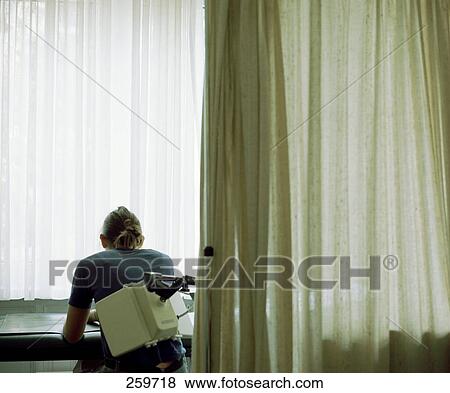 Stock Photo - Rear view of young woman undergoing fluoroscopy medical examination . Fotosearch