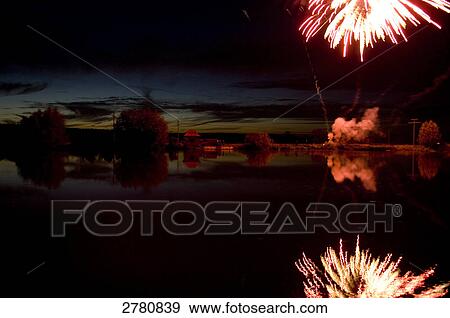 Stock Photo - Reflection of fireworks and clouds in water . Fotosearch