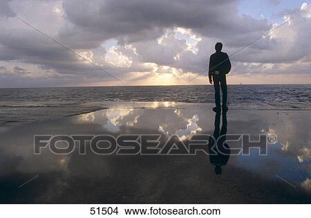 Silhouette of man standing on beach View Large Photo Image Picture - Silhouette of man standing on beach . Fotosearch
