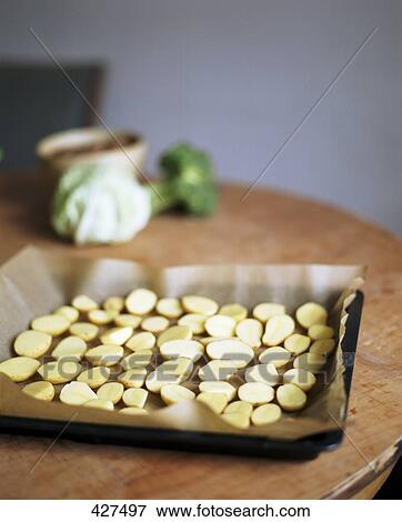 Slices of potato on baking tray View Large Photo Image Stock Photo - Slices of potato on baking tray . Fotosearch
