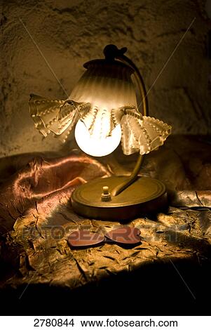Table lamp lit up on table View Large Photo Image Picture - Table lamp lit up on table . Fotosearch