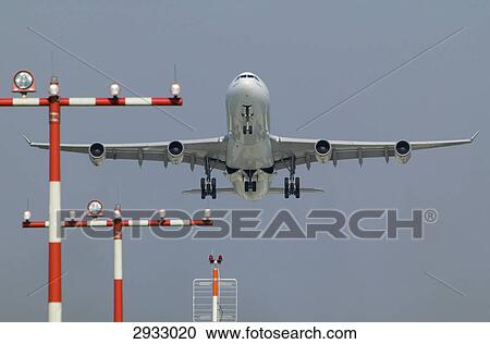 Stock Image - Airbus A340 landing, view from below . Fotosearch