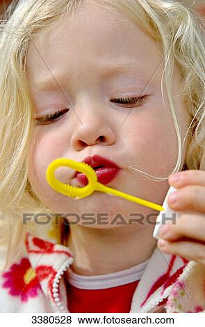 Stock Photo - Blond girl blowing bubbles . Fotosearch