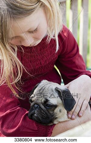 Blonde girl stroking pug View Large Photo Image Picture - Blonde girl stroking pug . Fotosearch