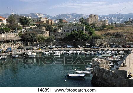 Boats at a marina with a town in the background, Byblos, Lebanon View Large Photo Image Stock Image - Boats at a marina with a town in the background, Byblos, Lebanon . Fotosearch