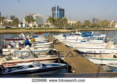 Boats at dock with buildings in background, Doha, Qatar View Large Photo Image Stock Photograph - Boats at dock with buildings in background, Doha, Qatar . Fotosearch