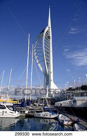 Stock Image - Boats moored at harbor with tower in background, Spinnaker Tower, Hampshire, England . Fotosearch
