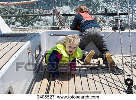 Boy and girl playing on a sailing yacht, elevated view View Large Photo Image Stock Photo - Boy and girl playing on a sailing yacht, elevated view . Fotosearch