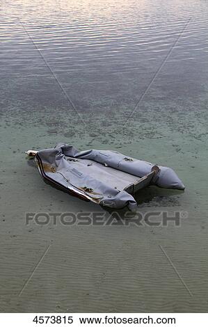Stock Photography - Broken rubber boat in ocean, Mallorca, Spain, Europe . Fotosearch