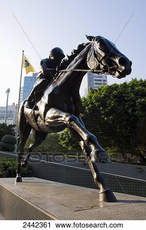 Stock Image - Bronze statue of jockey on pedestal, Hong Kong, China . Fotosearch