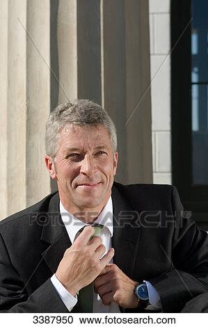 Businessman adjusting his tie View Large Photo Image Stock Image - Businessman adjusting his tie . Fotosearch