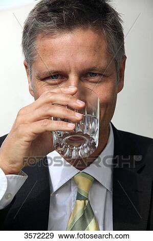 Businessman drinking water from glass, portrait View Large Photo Image Stock Photo - Businessman drinking water from glass, portrait . Fotosearch